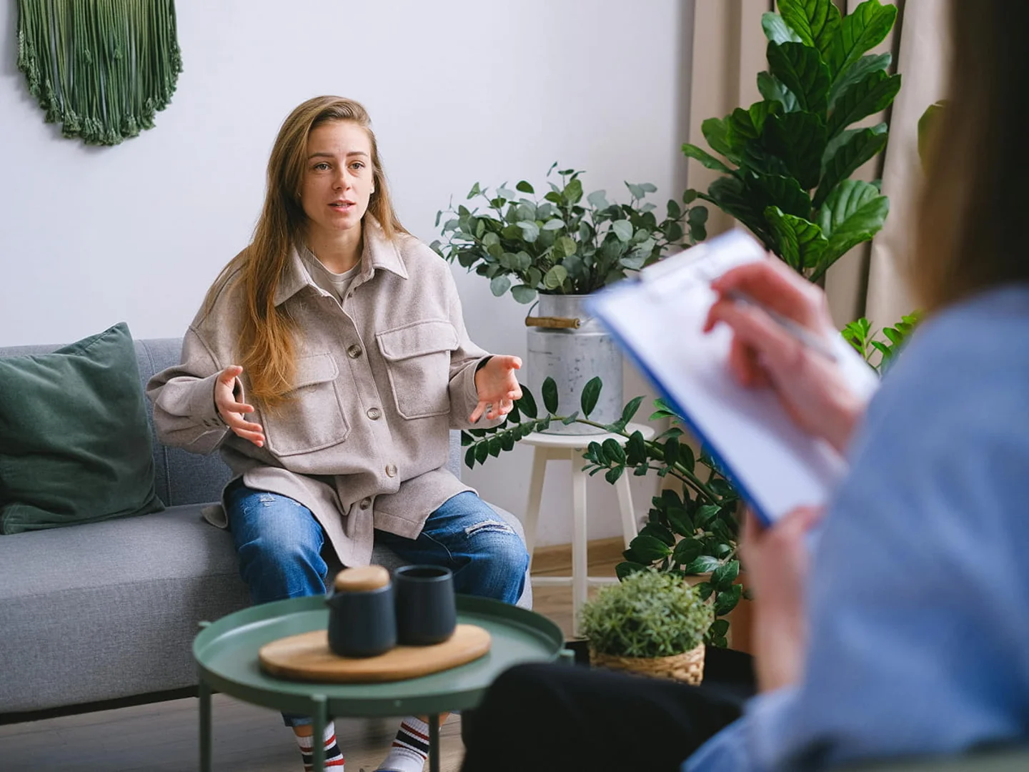 Two people sit together reviewing documents, one listening attentively to the other